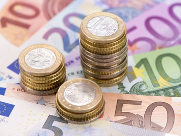 Drei unterschiedlich hohe Stapel aus Euromünzen auf Eurobanknoten - Nahaufnahme Drei unterschiedlich hohe Stapel aus Euromünzen auf Eurobanknoten - Nahaufnahme