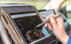 Hand mit Stift auf portablem Eingabegerät im Cockpit eines Fahrzeugs Hand mit Stift auf portablem Eingabegerät im Cockpit eines Fahrzeugs