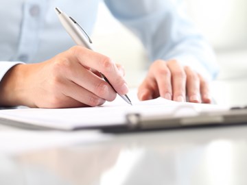 Hände mit Kugelschreiber auf Unterlagen Hände mit Kugelschreiber auf Unterlagen