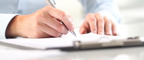 Hände mit Kugelschreiber auf Unterlagen Hände mit Kugelschreiber auf Unterlagen