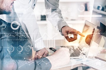 Zwei Männer im Büro vor einem Laptop, der eine deutet auf den Bildschirm - Bildmontage mit Grafiksymbolen Zwei Männer im Büro vor einem Laptop, der eine deutet auf den Bildschirm - Bildmontage mit Grafiksymbolen