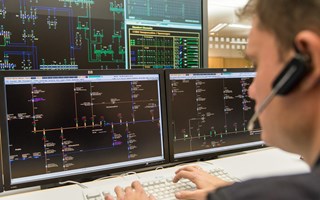 Mitarbeiter mit einem Headset vor mehreren Monitoren Mitarbeiter mit einem Headset vor mehreren Monitoren