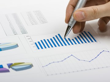 Hand mit Kugelschreiber über Diagrammen - Nahaufnahme Hand mit Kugelschreiber über Diagrammen - Nahaufnahme