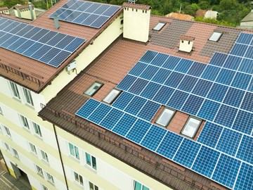 Luftaufnahme von Solarkraftwerk mit blauen Photovoltaik-Paneele n. Rand des Daches des Mehrfamilienhauses Luftaufnahme von Solarkraftwerk mit blauen Photovoltaik-Paneele n. Rand des Daches des Mehrfamilienhauses