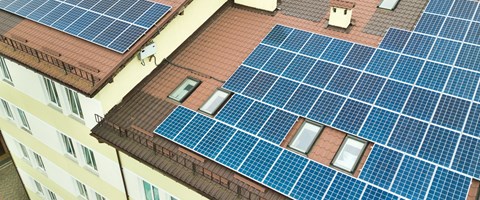 Luftaufnahme von Solarkraftwerk mit blauen Photovoltaik-Paneele n. Rand des Daches des Mehrfamilienhauses Luftaufnahme von Solarkraftwerk mit blauen Photovoltaik-Paneele n. Rand des Daches des Mehrfamilienhauses