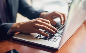 Nahaufnahme der Hände eines Geschäftsmannes auf einer Tastatur Nahaufnahme der Hände eines Geschäftsmannes auf einer Tastatur