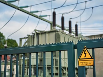 Zaun mit Warnschild vor Hochspannung an einem Umspannwerk Zaun mit Warnschild vor Hochspannung an einem Umspannwerk